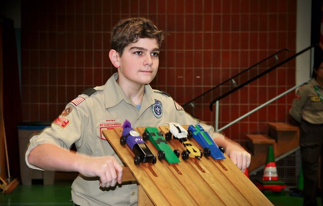 Boy Scout volunteer Stuart Arnold, age 13, launches a “WEBELO” Den heat during the Pack 69 Pinewood Derby held Jan. 23 at Vogelweh Elementary School. Over 30 cars competed during the annual Scout racing extravaganza. Siblings, parents and adult volunteers as well as scouts designed, cut and decorated wooden cars for the competition.
