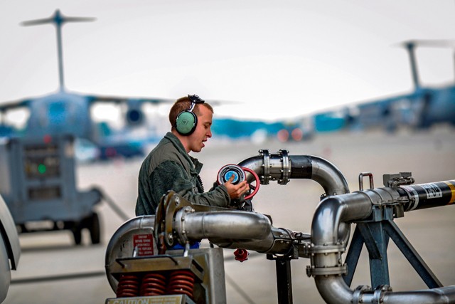 Photo by Senior Airman Nicole Sikorski  Staff Sgt. Adam Hart, 721st Aircraft Maintenance Squadron electrical and environmental systems specialist, disconnects a refueling pump from a C-17 Globemaster III before a flight to Bulgaria June 20, 2015, on Ramstein. Airmen and Soldiers worked together to load two M1A2 Abrams main battle tanks onto the aircraft over a span of two days.