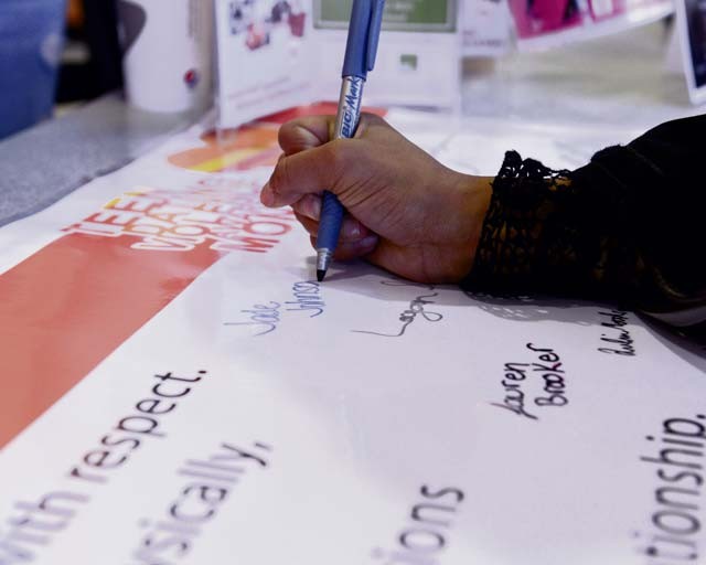 Teens sign a pledge banner at the Kaiserslautern Military Community Center food court during Teen Dating Violence Awareness month Feb. 5 on Ramstein. The banner was placed at a booth to help raise awareness of teen dating violence and will be hung in the Teen Center for the remainder of the month. Teens from around the KMC were able to sign the banner as a pledge to be in respectful, violence-free relationships. Family Advocacy will also have a ‘Parenting of Teens’ class for both parents and teens to attend to learn how to have open communication. For more information, contact Family Advocacy at 479-2370 or 06371-46-2370.