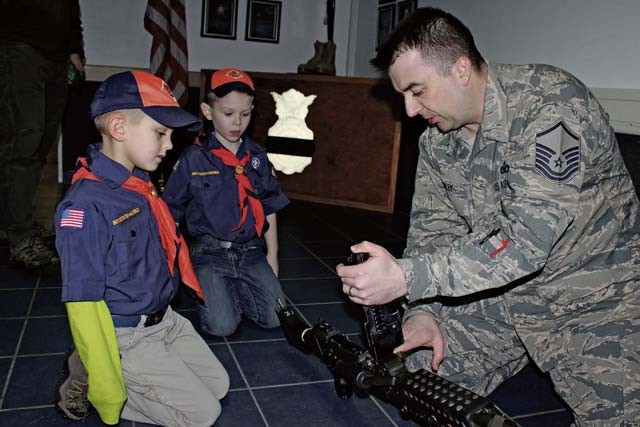 Master Sgt. Gregory Riley, 86th Security Forces Squadron NCO in charge of police services, shows Cub Scouts an M240B Machine Gun Feb. 3 on Ramstein. Airmen from the 86th SFS gave local Cub Scouts a tour of their facilities and taught them about some of the weapons they might carry.