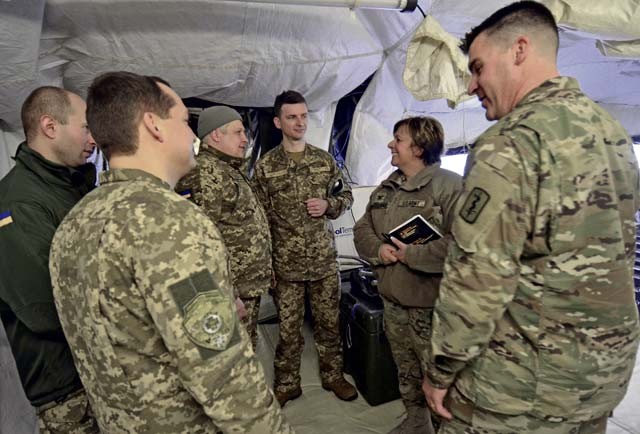 Col. Ann Naclerio, U.S. Army Europe deputy command surgeon, and Lt. Col. Wes Clarkson, 212th Combat Support Hospital physician, talk with Ukrainian military surgeons Capt. Pavlo Shkliarevych, Maj. Serhii Shypilov, Lt. Col. Mykola Moskvychov and 1st Lt. Volodymyr Prytula during a visit to the 212th CSH’s Mobile Early Entry Package field hospital Jan. 27 at a training area near Wiesbaden. The four Ukrainian surgeons spent a week learning about Army Medicine in Europe at Landstuhl Regional Medical Center and with the 212th CSH.