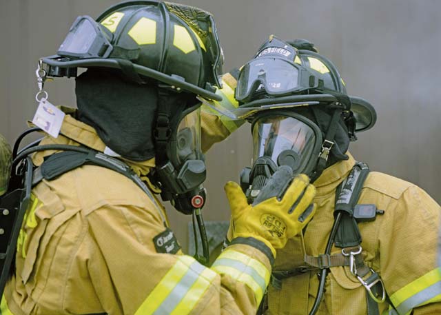Firefighters from the 65th Civil Engineer Squadron test the seal of their oxygen masks before combatting a structural fire at their training facility Feb. 6 on Lajes Field, Azores, Portugal.