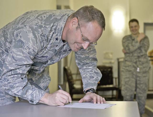 Brig. Gen. Jon T. Thomas, 86th Airlift Wing commander, signs a pledge to kick off the 2016 Air Force Assistance Fund campaign March 21 on Ramstein. The program is designed to allow Airmen to help others through the program’s charitable affiliates that provide support to Airmen and their dependents, including those in emergencies and those who need help paying for educational costs.