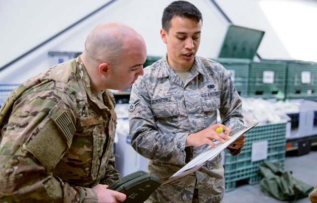 Airman 1st Class Cierra Dominguez, 86th Logistic Readiness Squadron individual protective equipment journeyman (right), shows Capt. Rosario Digangi, 435th Contingency Response Squadron operations flight commander, a list of items being issued April 11 on Ramstein. Digangi and other 435th CRS members processed through a deployment line to ensure all documents and procurement of necessary equipment was completed for a future mission.