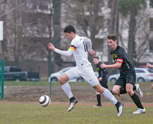 Antonio Oduber, team captain and senior at Ramstein High School, dribbles past a Stuttgart High School varsity soccer player during a match March 26 at RHS. 