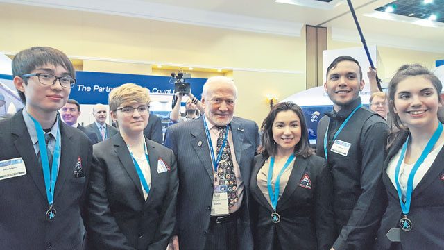 The Kaiserslautern High School StellarXplorers team meets astronaut Buzz Aldrin at the 32nd Space Symposium April 14 in Colorado Springs, Colorado. From left to right: Vincent Povilaitis, junior; Karina Sahli, freshman; Buzz Aldrin; Rhiannon Jimenez, senior; Nathan Throckmorton, senior; and Sandra Mako-Sanchez, junior.