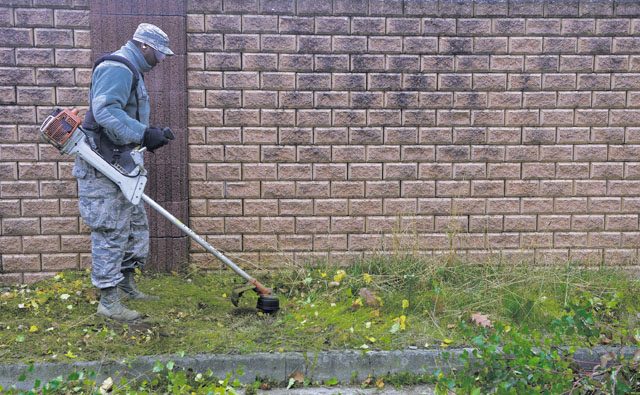 Photo by 1st Class Lane Plummer  Senior Airman Devonte Jenkins, 786th Civil Engineering Squadron heating, ventilation, air conditioning and refrigeration journeyman, uses a weed whacker around his working area during a base-cleanup day Nov. 3, 2015, on Ramstein. Airmen and civilians around Ramstein cleaned around the base to maintain a clean working environment. 