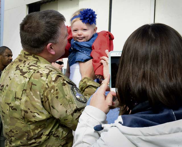 Maj. Thomas Chapman, 76th Airlift Squadron chief of training, holds his daughter after returning from a deployment March 15 on Ramstein. Spouses, children, friends and co-workers welcomed the Airmen home and thanked them for their commitment, sacrifice and dedication to the mission.