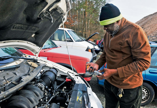 Herbert Doyle, Landstuhl Regional Medical Center lodging laborer, removes a car part at the Ramstein Automotive Recycling Center March 1 on Ramstein. The recycling center accepts unservicable cars to sell as parts as well as whole cars to sell to the highest bidder.