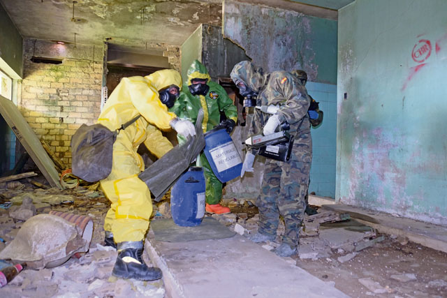 A combined assessment team was made up of two Spanish army Recon Regiment Soldiers, one Spanish Emergency Military Unit member and U.S. Army Staff Sgt. Shawn McKenna, 773rd Civil Support Team, 7th Mission Support Command (center), conduct a site assessment of a suspected chemical-spill site inside an abandoned building spray painted with murals of graffiti and littered with brick, concrete and debris April 5 in Sevilla, Spain. U.S. Army Reserve Soldiers from the 7th MSC conducted combined joint partnered foreign consequence management disaster response operations with personnel from U.S. Navy Combined Joint Task Force 68 as part of more than 100 military members and civilians as part of the Combined Joint Task Force - Foreign Consequence Management in support of the Spanish Emergency Military Unit first responders and Spanish army Recon Regiment during disaster emergency response exercise Combined Joint Exercise SUR 2016.
