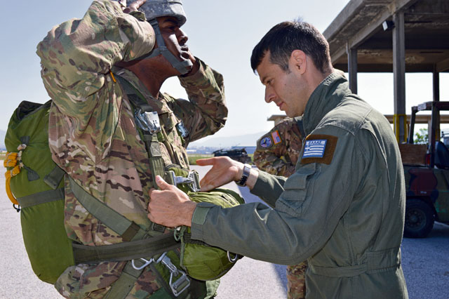 Photo by Sgt. Brenda ContrerasGreek air force Capt. Konstantinos Kainourios, 865th Aerial Delivery Battalion jumpmaster (right), places the static-line hook onto the parachute of Sgt. 1st Class Ronnell Gillespie, 5th Quartermaster Theater Aerial Delivery platoon sergeant, April 6 in Elefsis, Greece.