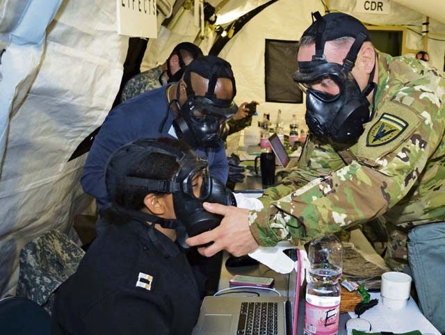 A U.S. Army officer and civilian check the seal on the protective mask of a U.S. Navy officer May 2 during Exercise Anakonda Response 2016 at Papa Air Base, Hungary. For the roughly two-week-long event, the U.S. organized a full assembly of military representation, including the Army, Navy, Marine Corps, Army Reserve, Army National Guard and Air National Guard. Also, the Hungarian military hosted the United Kingdom’s Royal Army and Corps of Royal Marines.