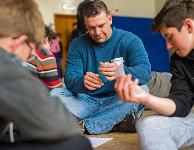 Master Sgt. Michael Peters, U.S. Air Forces in Europe long haul systems communications manager, creates origami shapes with local national children during a community engagement event April 23 in Landstuhl.