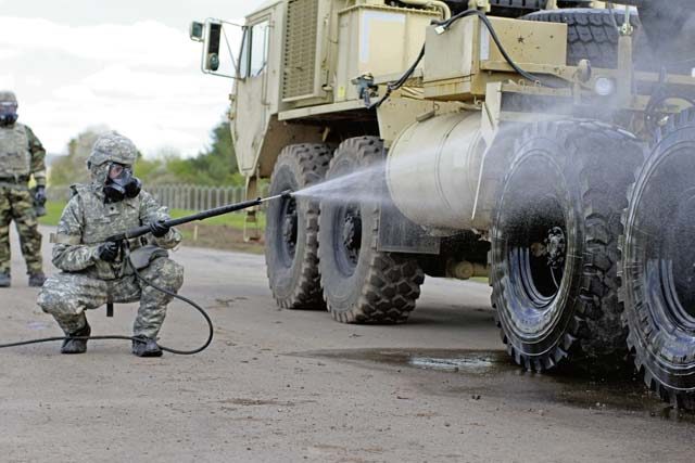 Photos by Spc. Jasmin Flores A Soldier decontaminates a Patriot Launcher in mission-oriented protective posture 4 to simulate a real-life scenario during chemical, biological, radiological and nuclear training for Soldiers from the 10th Army Air and Missile Defense Command on Baumholder Army Airfield.
