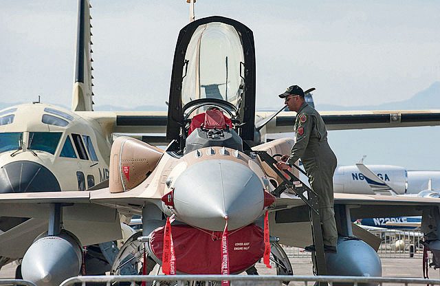 A Moroccan F-16 pilot shows the inside of an aircraft to a spectator during the International Marrakech Air Show April 28 in Morocco.