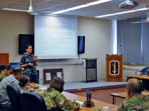 Capt. Kimberly Ferland, lead NATO evaluator, gives the First Impression Report to the 212th Combat Support Hospital commander and key leaders. This initial report, which found the unit fully capable or capable in all areas, will be the basis of the official certification, which will occur later at NATO headquarters.