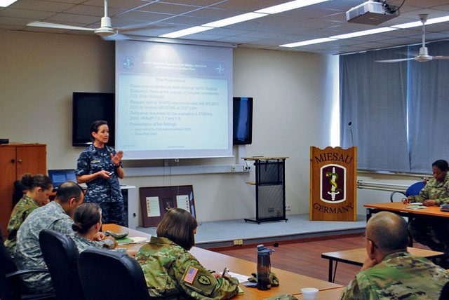 Capt. Kimberly Ferland, lead NATO evaluator, gives the First Impression Report to the 212th Combat Support Hospital commander and key leaders. This initial report, which found the unit fully capable or capable in all areas, will be the basis of the official certification, which will occur later at NATO headquarters.