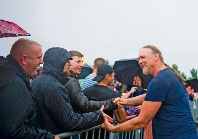 Trace Adkins shakes audience members’ hands during a free concert June 11 on Ramstein. Adkins came down from the stage to greet fans after the event was briefly interrupted by heavy rain.