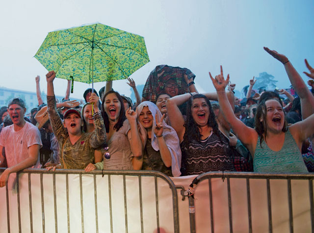 Audience members cheer during a free concert performed by Trace Adkins June 11 on Ramstein. The event was briefly interrupted by heavy rain and resumed after Adkins came down from the stage to shake hands with the audience members.