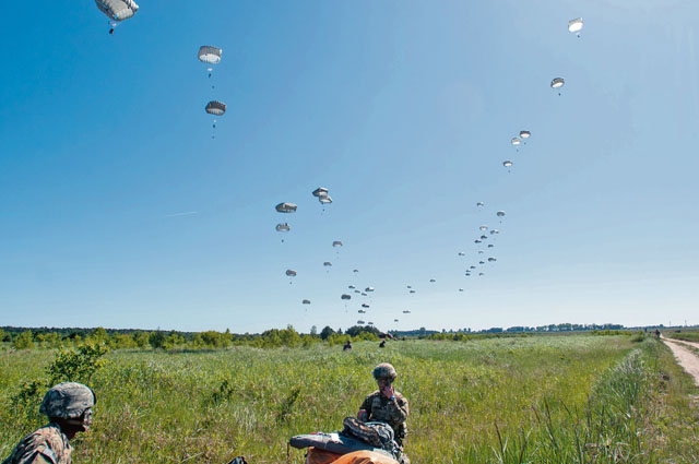Photo by Capt. Jeku ArceRoving medics from the 557th Medical Company watch a wave of paratroopers jump to determine where they may land on the drop zone in support of Swift Response 16 June 7 in Poland. 