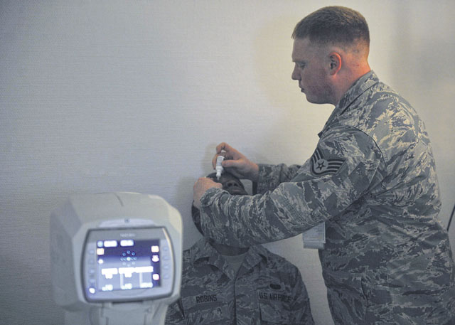 Staff Sgt. Christopher Simpson, 86th Aerospace Medicine Squadron optometry technician (right), administers pupil-dilating drops to Senior Airman Jonathan Robins, 1st Combat Communications Squadron maintenance operations center technician, during an eye exam June 23 on Ramstein. The clinic offers a variety of services including routine eye exams, diagnosing and treating diseases, retraining physicals, school screenings and refractive surgery.