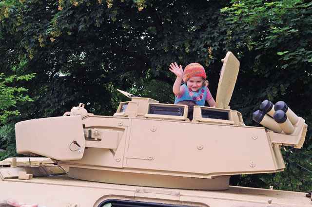 A young German girl tests the comfort level of a Bradley fighting vehicle at Rheinland-Pfalz Day 2016 June 4 in Alzey, Germany. Rheinland-Pfalz Day is a multiday event featuring entertainment and informative displays and booths from various regional organizations. U.S. participation in the event included several demonstrations and displays by 21st Theater Sustainment Command organizations.