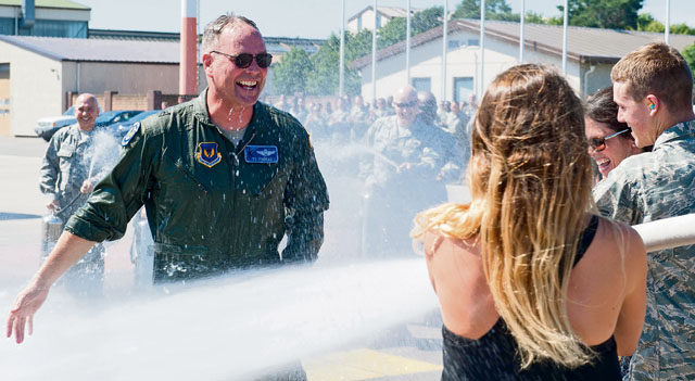 Brig. Gen. Jon T. Thomas, 86th Airlift Wing commander, approaches his family as he gets hosed down with water during his “fini flight” July 20 on Ramstein. Fini flights have been a tradition for pilots that are changing bases since World War II. The pilots fly their assigned aircraft one last time and are greeted by Airmen, family and friends after landing.