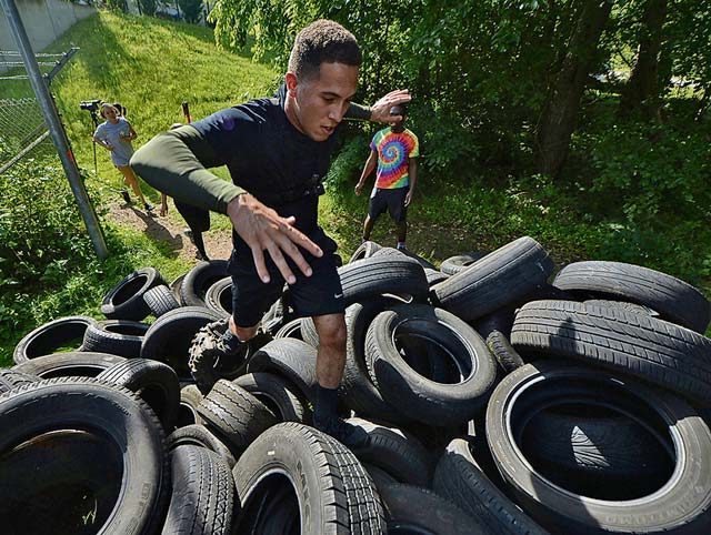 Senior Airman Corinthian Maldonado, 86th Airlift Wing commander executive administrator, climbs a hill of tires at the Mudless Mudder on Ramstein Air Base July 8, 2016. More than 550 participants competed in the five-kilometer obstacle course for the 86th AW Resiliency Day.