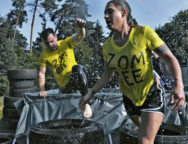 Mudless Mudder participants climb out of a pool of water July 8, 2016, at Ramstein Air Base. The five-kilometer obstacle course contained 15 events including monkey bars, a rope walk, tire carry and pallet climb. 