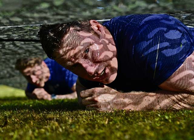 A Mudless Mudder participant low crawls July 8, 2016, at Ramstein Air Base. The 86th Airlift Wing hosted the five-kilometer obstacle course for Resilience Day.