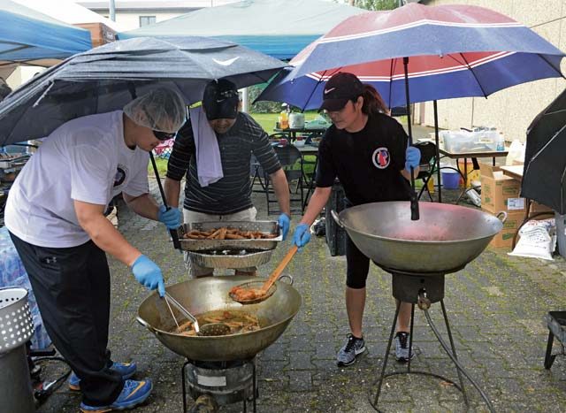 Volunteers with the Filipino-American Association of the Kaiserslautern Military Community fry egg rolls in the rain during Freedom Fest 2016 at Ramstein Air Base, July 4, 2016.