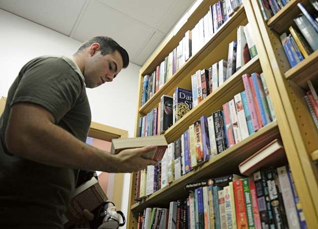 Photo by Airman 1st Class Joshua Magbanua  Airman 1st Class Jacob Fraas, 721st Aircraft Maintenance Squadron crew chief, looks at donated books at the Airman's Attic at Ramstein Air Base, June 24, 2016. The Airman’s Attic offers a wide range of household goods, clothing, electronics and toys to active duty military members E-5 and below. 