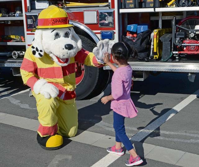 Sparky the Fire Dog gives a child a high-five at a block party Aug. 5 on Ramstein. All Department of Defense cardholders and their families with access to the base were able to attend the block party.