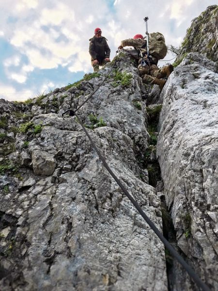 A German soldier helps a comrade from the 18th Military Police Brigade to the summit during a ropes training exercise conducted as part of exercise Alpendistel 2016.