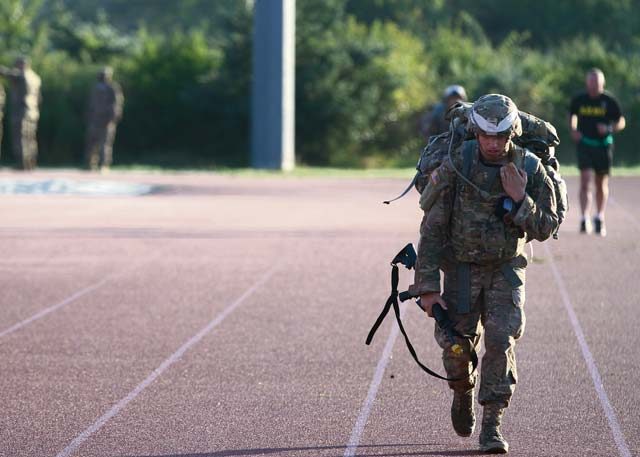 Staff Sgt. Andrew MacKenzie, 10th Army Air and Missile Defense Command, trudges toward the finish line after completing a grueling 12-mile foot march Aug. 11, the final day European Best Warrior Competition, at the Grafenwoehr Training Area, Germany.