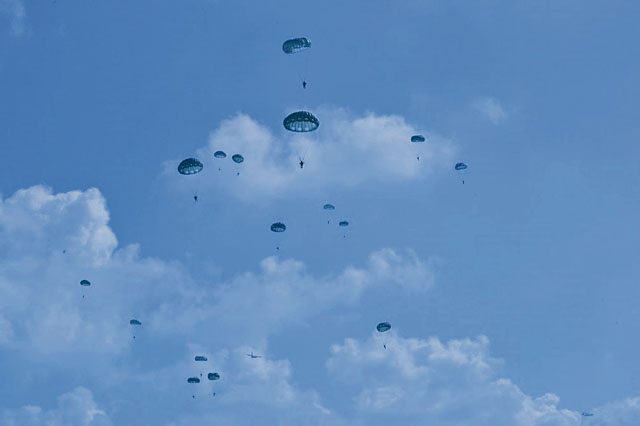 Photo by Staff Sgt. Daniel Wyatt Parachutists dot the sky after jumping from a C-130J Super Hercules during International Jump Week July 27 over Bitburg Airfield, Germany. Over 150 parachutists from the U.S. and seven other countries participated in the weeklong annual event designed to build partnership capacity by conducting airborne operations.
