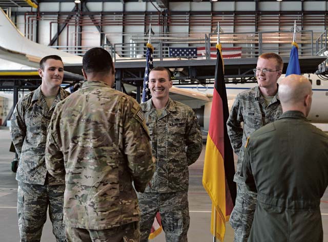 Photo by Senior Airman Nesha Humes  Airmen talk after a coin ceremony Aug. 10, 2016, on Ramstein Air Base. Master Sgt. James McConaghay, U.S. Air Forces in Europe directorate contingency manager, Tech Sgt. David Hobeck, 86th Maintenance Squadron unit deployment manager, Tech Sgt. Austin Schierberg, 86th MXS repair and reclamation craftsman, Staff Sgt. Cory Garland, 86th MXS repair and reclamation journeyman and Staff Sgt. Geoffrey Brew, 86th MXS UDM, were recognized for successful completion of an aircraft recovery mission. 