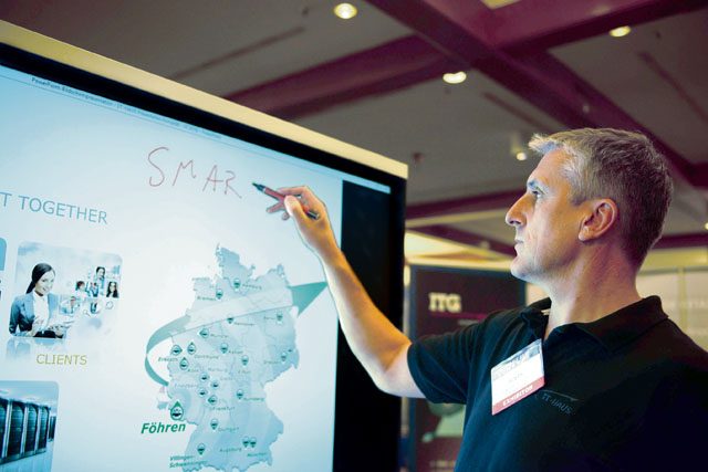 Alwin Puschmann, IT-Haus representative, writes on the screen of an interactive digital whiteboard system July 19 on Ramstein. Puschmann was a representative of one of more than 60 companies that showcased their technologies at the Ramstein Technology Exposition.