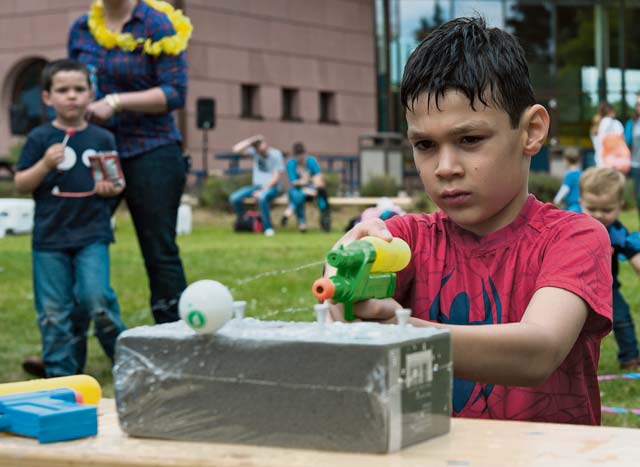 Photo by Airman 1st Class Lane T. Plummer  A child squirts a ping pong ball with a water gun during a party for families of deployed Airmen Aug. 12, 2016, at Ramstein Air Base.