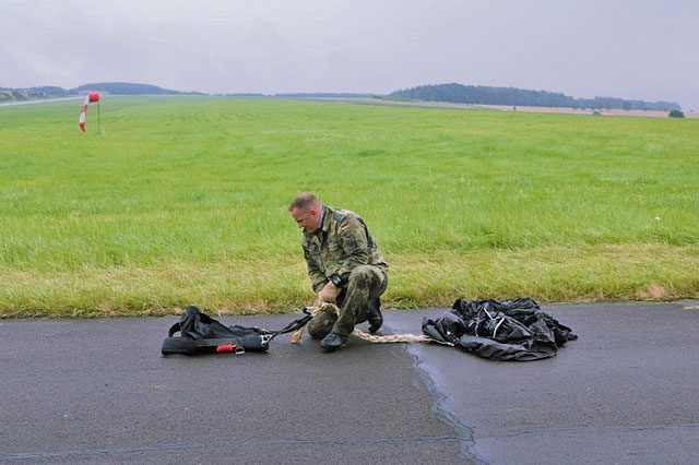 A German parachutist packs his bag after jumping from a U.S. Army CH-47 Chinook during International Jump Week July 27 on the drop zone in Bitburg, Germany. Over 150 parachutists from the U.S. and seven other countries participated in the weeklong annual event designed to build partnership capacity by conducting airborne operations.