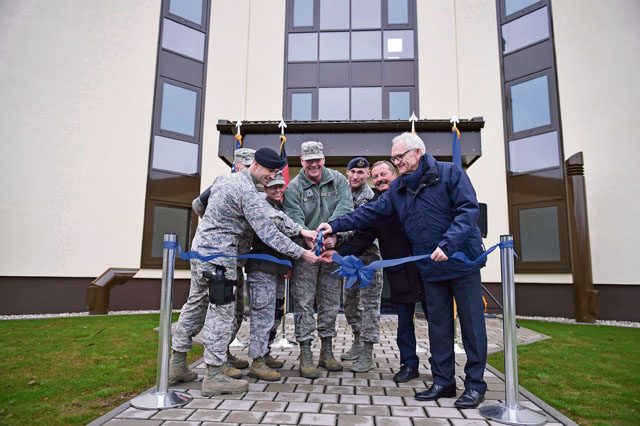Photo by Staff Sgt. Sara Keller Brig. Gen. Jon T. Thomas, 86th Airlift Wing commander, and 569th U.S. Forces Police Squadron leaders cut a ribbon for the grand opening of dorm 2818 Feb. 5 on Kapaun. The new dorm was constructed to be more energy efficient to help cut costs and maintain a healthier environment for Airmen that will live there.