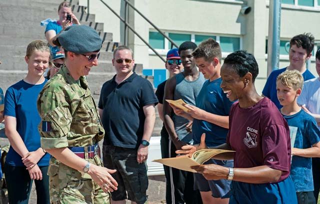Chief Master Sgt. Tamar Dennis, Kisling NCO Academy commandant (right), rewards Rebecca Kirk, Royal Air Force Reserve flying officer, with a certificate recognizing her participation in a series of exercises during Warrior Day Aug. 8 on Vogelweh. At the end of each day, the air cadets were rewarded for their hard work with certificates that acknowledged they successfully exercised admirable cooperative skills.