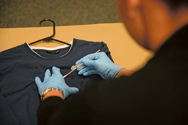 An Air Force Office of Special Investigations 13th Field Investigations Squadron agent demonstrates a presumptive blood test on a shirt Aug. 11, 2016, at Ramstein Air Base. A presumptive blood test is conducted to confirm whether or not blood is present on a piece of evidence. 
