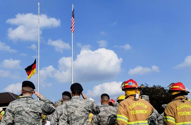Photos by Senior Airman Tryphena Mayhugh Airmen from the 86th Airlift Wing salute during the lowering of the German flag Sept. 9 on Ramstein. The Airmen were participating in a 9/11 memorial retreat ceremony to honor the 2,977 lives lost during the attacks.