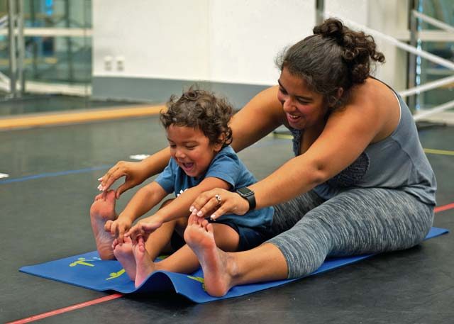 Kadyzshea Barrios and her son, Roy, reach for their toes during a Mommy and Me Yoga class Aug. 29 on Ramstein. This is the first Mommy and Me Yoga class to be offered at Ramstein.