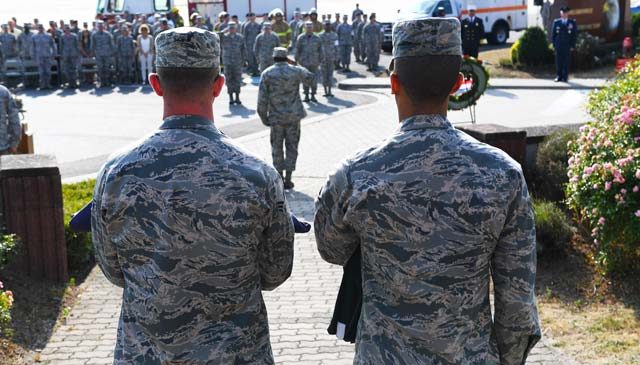 Two 86th Airlift Wing Airmen hold folded American and German flags during a 9/11 memorial retreat ceremony Sept. 9 on Ramstein. Of the 2,977 people who lost their lives in the attacks, 343 were firefighters, 72 were law enforcement officers and 55 were military personnel who were first responders at the World Trade Center.