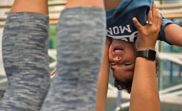 Kadyzshea Barrios lifts her son, Roy, in the air with her feet during the first Mommy and Me Yoga class Aug. 29 on Ramstein. Compared to a yoga course for adults, the Mommy and Me Yoga classes have more movement and hold poses for shorter amounts of time.