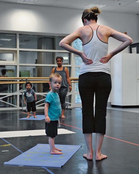 Students stand on their mats during the first Mommy and Me Yoga class Aug. 29 on Ramstein. During the class, children learn to follow directions and increase balance, muscle strength and coordination with the help of both the teacher and parent.