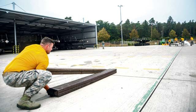 Staff Sgt. Benjamin Patton, 435th Contingency Response Squadron mobile aerial porter, lifts the last pieces of dunnage as the rest of his team moves a pallet during the physical challenge obstacle course of the 2016 European Port Dawg Rodeo Sept. 17 on Ramstein. During the course, Airmen had to unload a pallet, move the items and pallet approximately 100 yards away, rebuild the pallet and run a relay around an apron.