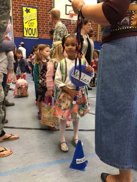 Khloe Wright, Landstuhl Elementary Middle School student, holds a lollipop for her new kindergarten teacher, Trudy Lee, before her first day of kindergarten Sept. 6 at LEMS.